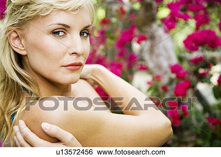 Beauty portrait of a woman in a tropical setting with her arms wrapped around herself. View Large Photo Image Stock Photograph - Beauty portrait of a woman in a tropical setting with her arms wrapped around herself.. Fotosearch