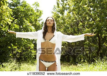 Stock Image - Beauty portrait of a woman strolling in a tropical setting.. Fotosearch