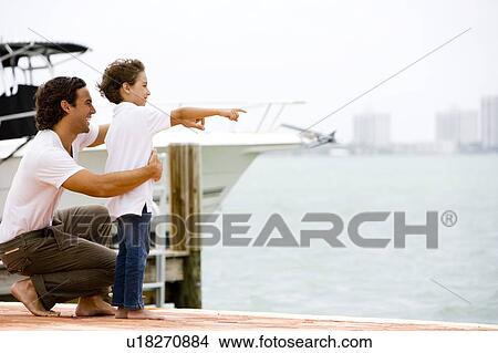 Picture - father and son looking across bay from dock. Fotosearch