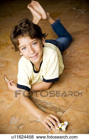 Latino boy playing with toy car on floor View Large Photo Image Stock Photo - Latino boy playing with toy car on floor. Fotosearch