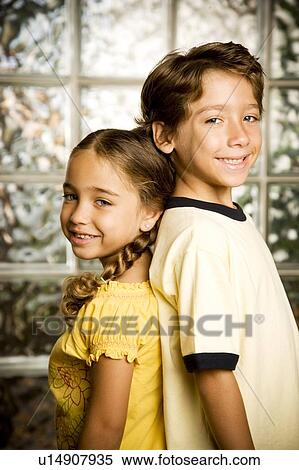 Latino brother and sister standing back to back View Large Photo Image Stock Photography - Latino brother and sister standing back to back. Fotosearch