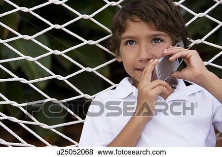 little boy talking on cell phone sitting in hammock View Large Photo Image Stock Photo - little boy talking on cell phone sitting in hammock. Fotosearch