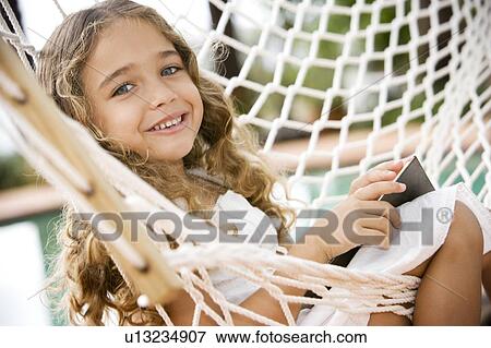Stock Photo - little girl sitting in a hammock. Fotosearch