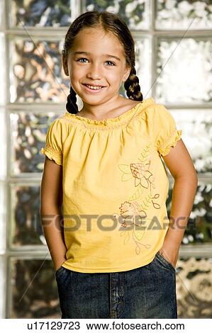 Stock Image - little girl smiling, hands in pockets. Fotosearch