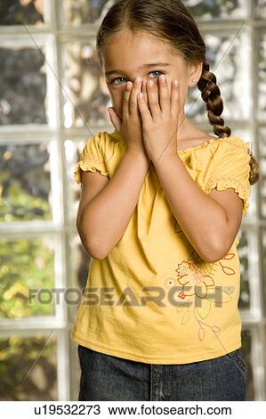 Stock Image - little girl with hands over her face. Fotosearch