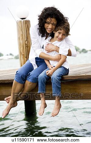 mother squeezing son sitting on jetty View Large Photo Image Stock Image - mother squeezing son sitting on jetty. Fotosearch