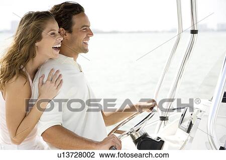 Couple on board a luxury yacht, man steering View Large Photo Image Stock Image - Couple on board a luxury yacht, man steering. Fotosearch