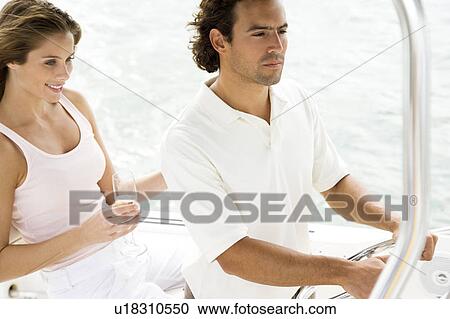 Couple on board a luxury yacht, man steering View Large Photo Image Stock Image - Couple on board a luxury yacht, man steering. Fotosearch