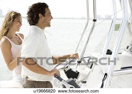 Couple on board a luxury yacht, man steering View Large Photo Image Stock Image - Couple on board a luxury yacht, man steering. Fotosearch
