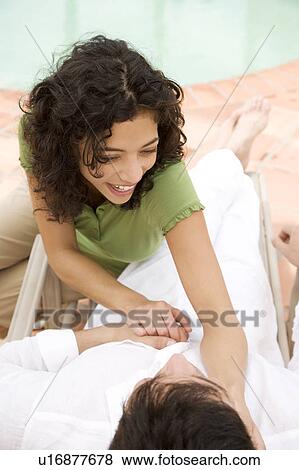 Stock Photo - Couple relaxing by the pool. Fotosearch