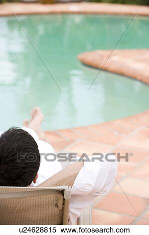 Stock Photography - Man relaxing by the pool. Fotosearch