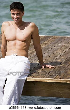 Topless man sunbathing on a jetty View Large Photo Image Stock Image - Topless man sunbathing on a jetty. Fotosearch