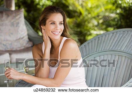 Woman sitting outside in the sunshine, having a drink View Large Photo Image Stock Image - Woman sitting outside in the sunshine, having a drink. Fotosearch