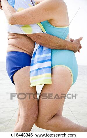Stock Photograph - Close up portrait of a senior couple wrapped in a towel at the beach. Fotosearch