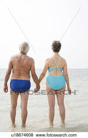 Portrait of a senior couple hand in hand walking in the sea View Large Photo Image Stock Photo - Portrait of a senior couple hand in hand walking in the sea. Fotosearch