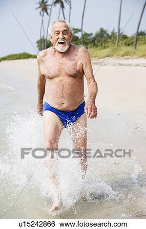 Portrait of a senior man in swimming trunks at the beach View Large Photo Image Stock Photograph - Portrait of a senior man in swimming trunks at the beach . Fotosearch