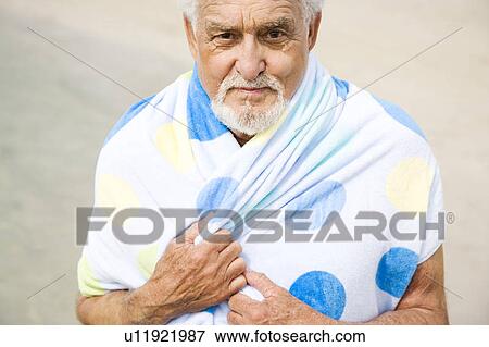 Portrait of a senior man wrapped in a towel at the beach View Large Photo Image Stock Photo - Portrait of a senior man wrapped in a towel at the beach . Fotosearch