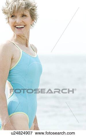 Stock Photo - Portrait of a smiling senior woman in a swimsuit at the beach . Fotosearch