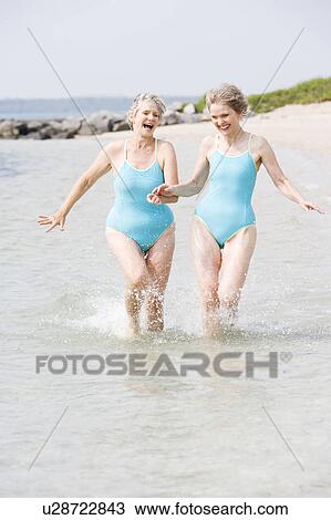 Portrait of a two senior women hand in hand running in the sea View Large Photo Image Stock Image - Portrait of a two senior women hand in hand running in the sea. Fotosearch