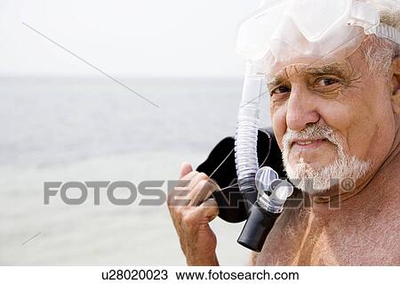 Senior man with snorkel gear and flippers at the beach View Large Photo Image Stock Image - Senior man with snorkel gear and flippers at the beach . Fotosearch