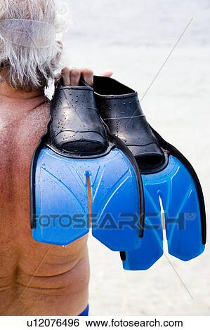 Senior man with snorkel gear and flippers at the beach looking out to sea View Large Photo Image Stock Photograph - Senior man with snorkel gear and flippers at the beach looking out to sea. Fotosearch