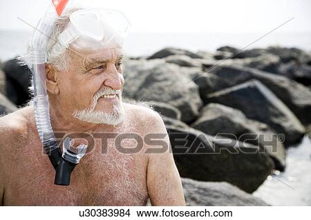 Picture - Senior man with snorkel gear at the beach . Fotosearch