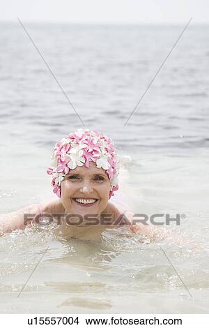Senior woman in a swimming hat, swimming in the ocean View Large Photo Image Picture - Senior woman in a swimming hat, swimming in the ocean . Fotosearch
