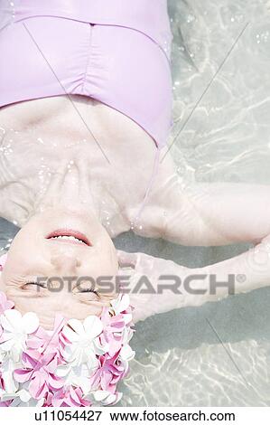 Senior woman in a swimming hat, floating in the ocean View Large Photo Image Stock Photo - Senior woman in a swimming hat, floating in the ocean . Fotosearch