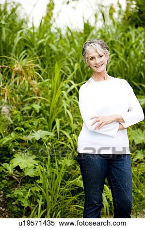 Portrait of a smiling senior woman in front of tropical foliage View Large Photo Image Stock Photography - Portrait of a smiling senior woman in front of tropical foliage . Fotosearch