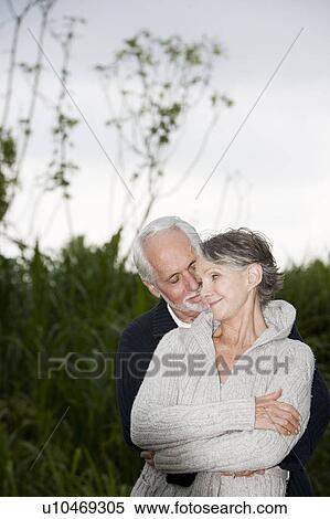 Stock Photography - Senior couple smiling and embracing . Fotosearch