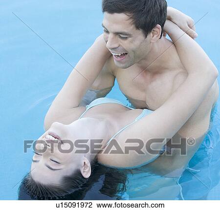 Stock Image - A couple embracing in a pool. Fotosearch