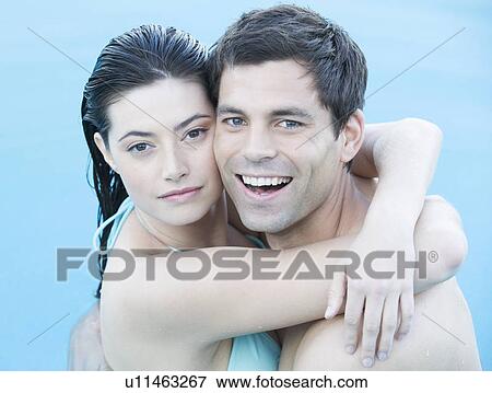 Stock Photo - A couple embracing in a pool. Fotosearch