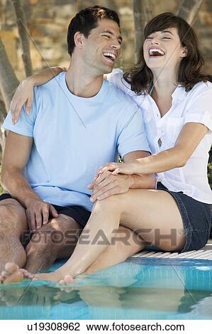 A couple relaxing by a pool View Large Photo Image Stock Image - A couple relaxing by a pool. Fotosearch