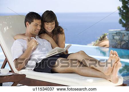 A couple relaxing by a pool View Large Photo Image Stock Photo - A couple relaxing by a pool. Fotosearch