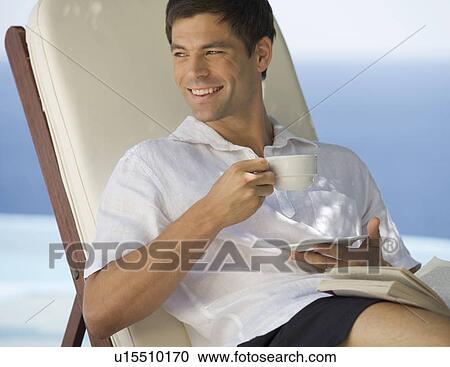 Stock Image - A man relaxing by a pool. Fotosearch