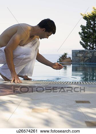 A man relaxing by a pool View Large Photo Image Stock Image - A man relaxing by a pool. Fotosearch