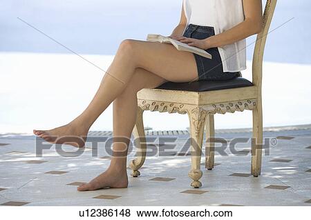 Stock Photo - A woman reading by a pool. Fotosearch