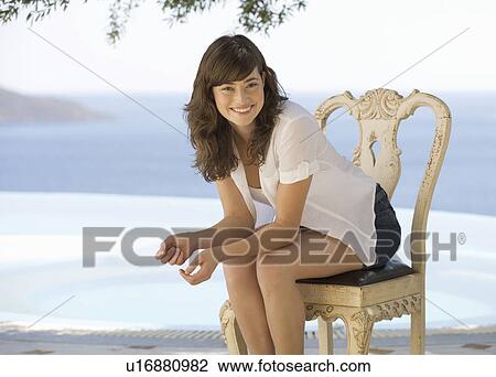 Stock Image - A woman relaxing by a pool. Fotosearch