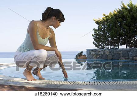 A woman relaxing by a pool View Large Photo Image Stock Image - A woman relaxing by a pool. Fotosearch