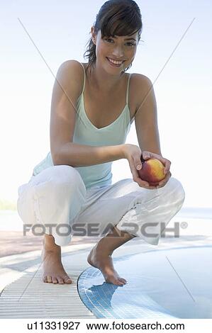 A woman relaxing by a pool View Large Photo Image Stock Photo - A woman relaxing by a pool. Fotosearch