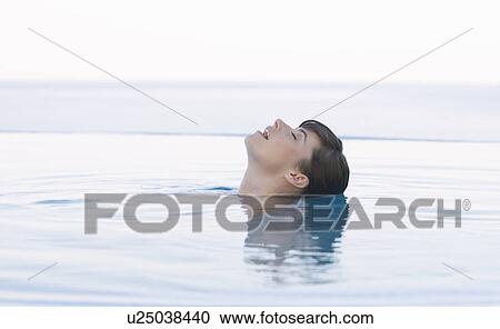 Stock Image - A woman relaxing in a pool. Fotosearch
