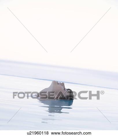 Stock Photo - A woman relaxing in a pool. Fotosearch