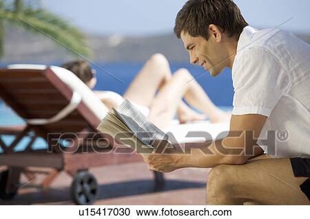 Two people relaxing by a pool View Large Photo Image Stock Image - Two people relaxing by a pool. Fotosearch
