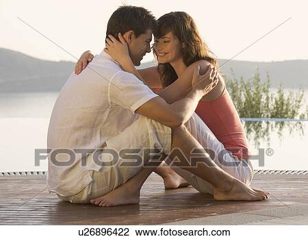 Stock Image - A couple embracing by a pool. Fotosearch