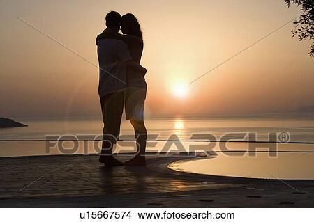 A couple watching the sun set View Large Photo Image Picture - A couple watching the sun set. Fotosearch