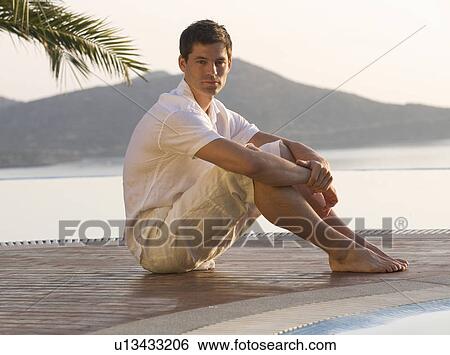 A man sitting by a pool View Large Photo Image Stock Photograph - A man sitting by a pool. Fotosearch
