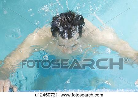 Stock Image - A man swimming in a pool. Fotosearch