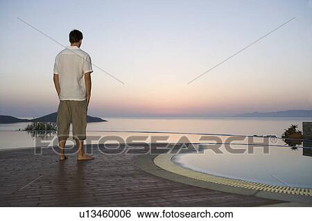 Stock Photograph - A man watching the sun set. Fotosearch