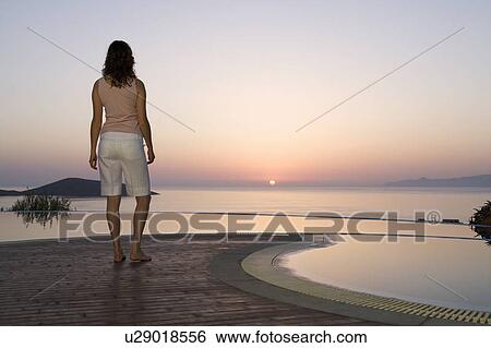 A woman watching the sun set View Large Photo Image Stock Photograph - A woman watching the sun set. Fotosearch