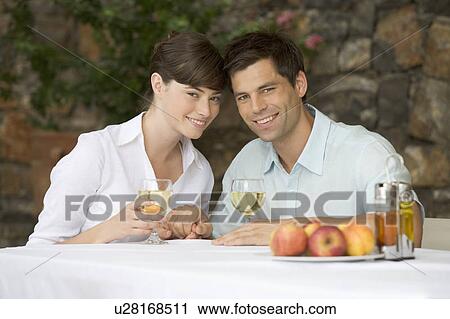 A couple sharing a bottle of wine at a table View Large Photo Image Stock Image - A couple sharing a bottle of wine at a table. Fotosearch